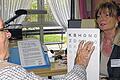 Buchstaben erkennen: Orthoptistin Sabine Kampmann prüft Erna Haupts Sehfähigkeit an der Lesetafel.