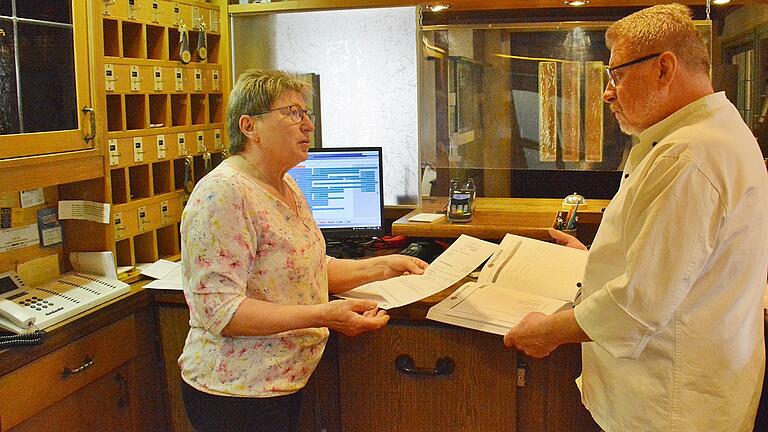 Volker und Christine Salzinger an der Theke ihres Hotels. Noch bleibt Zeit etwas zu besprechen, bevor die ersten Gäste kommen. Neben dem Hotel gibt es das Restaurant mit einem gemütlichen Außenbereich.