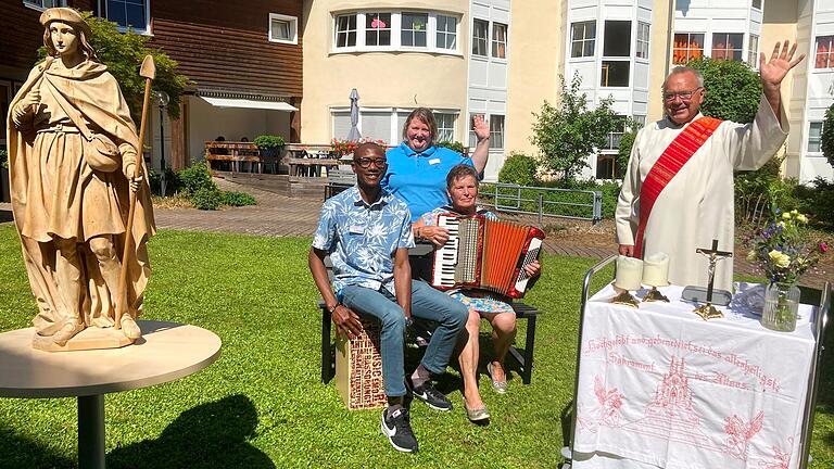 Im Garten der Dettelbacher Seniorenresidenz hinter dem 'Phönix-Altarmobil' Diakon Lorenz Kleinschnitz, Rita Selzam, Edward  Asolo und Dorina Bilz von der Beschäftigung.