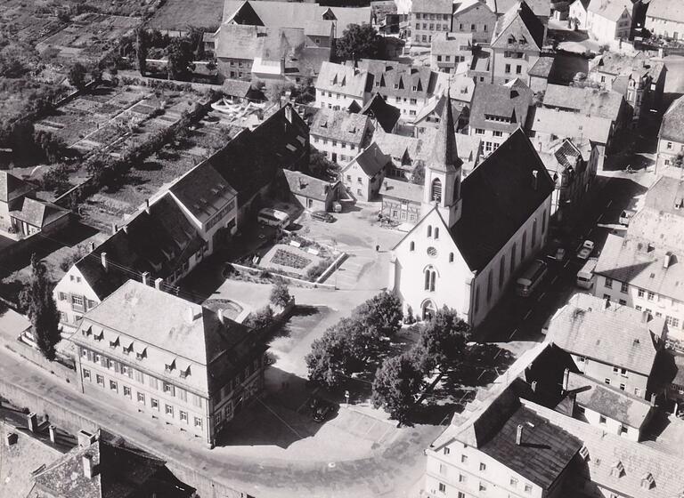 Das Luftbild von 1958 zeigt den damaligen Ortskern von Werneck mit dem Gemeindekrankenhaus (linke Häuserreihe), dem 1969 abgerissenen Amtsgericht (unten) und der 1968 abgebrochenen Kirche.