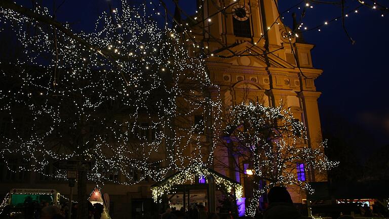 Der Platz der Partnerstädte als neuer Mittelpunkt des Weihnachtsmarktes war mit vielen Lichterketten geschmückt. Im Hintergrund ist die blau beleuchtete evangelische Stadtkirche zu sehen.