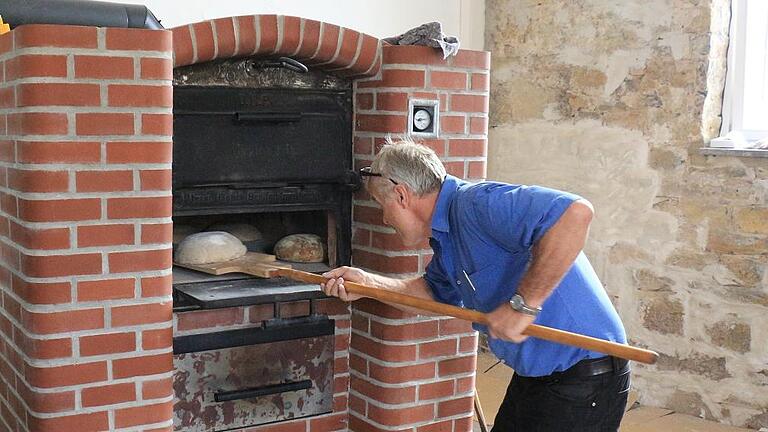 Paul Vierneusel schiebt beim Brotbacken in Rügheim in den Ofen ein. Paul Vierneusel schiebt beim Brotbacken in Rügheim in den Ofen ein.