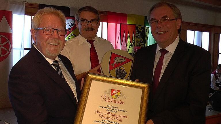 Bürgermeister Bernhard Ruß (rechts) erhielt aus den Händen von Zweitem Bürgermeister Gerhard Zösch (links) und Drittem Bürgermeister Paul Hümmer zu seinem Dienstjubiläum eine Dankesurkunde und ein Gemeindewappen. Bürgermeister Bernhard Ruß (rechts) erhielt aus den Händen von Zweitem Bürgermeister Gerhard Zösch (links) und Drittem Bürgermeister Paul Hümmer zu seinem Dienstjubiläum eine Dankesurkunde und ein Gemeindewappen.