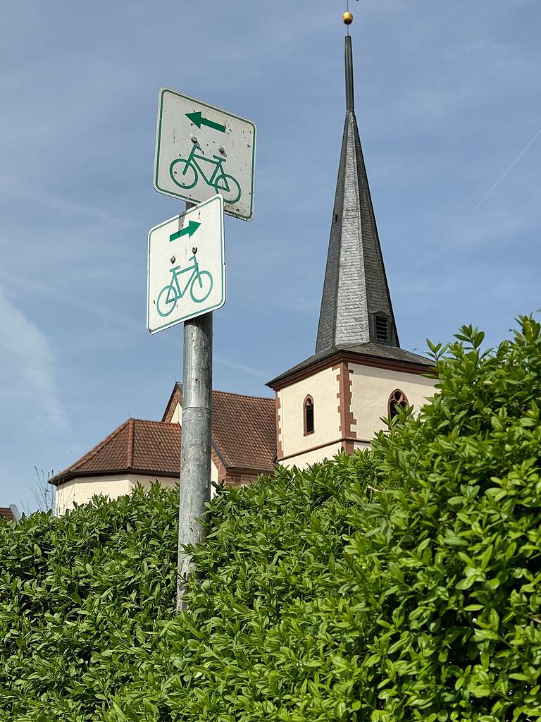 Hinter einer Hecke in Obererthal spitzt der Turm der Kirche St. Antonius hervor. Hinter einer Hecke in Obererthal spitzt der Turm der Kirche St. Antonius hervor.