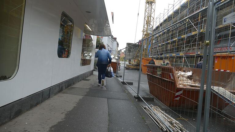 Eine Fußgängerin mit Einkaufstaschen – da wird es am Fotogeschäft (links) bei Begegnungen schon eng.