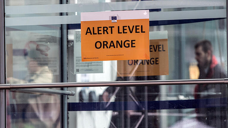 Anschläge in Brüssel       -  Ein Schild mit der Aufschrift 'Alert Level Orange' hängt am 23.03.2016 in Brüssel  an einem Gebäude der Europäischen Kommission. Bei einer neuen Terrorserie sind am Dienstag in Brüssel mehr als 30 Menschen getötet worden. Die Zahl der Verletzten liegt bei mehr als 180.