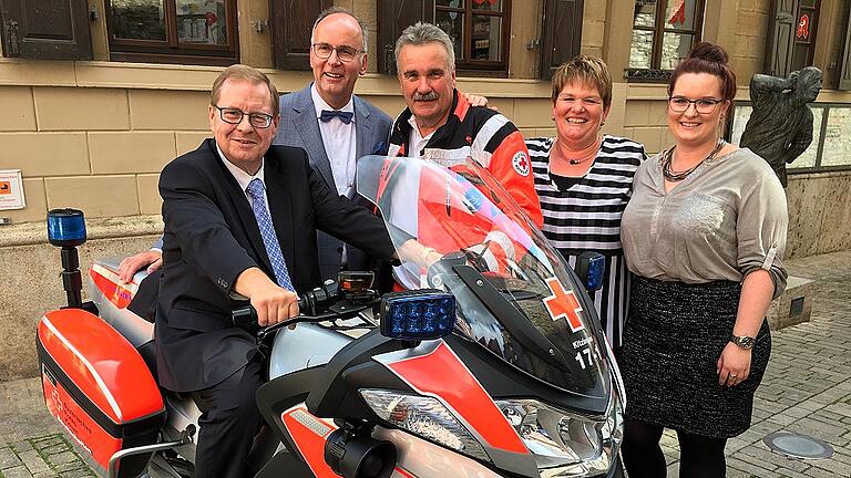 GOK-Jubiläum: 50 Jahre steuern, regeln und helfen       -  Probesitzen auf der Spende: Der Marktbreiter GOK-Inhaber Dieter Kleine testet das Motorrad, das sein Unternehmen dem BRK-Kreisverband Kitzingen gespendet hat. Mit ihm freuen sich über die Spende GOK-Geschäftsführer Gerald Unger, Motorradstaffel-Leiter Hanns Strecker, Kleines Ehefrau Maria und seine Tochter Evelyn (von links).