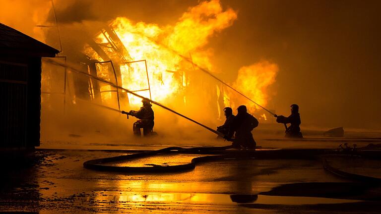 AdobeStock_64529909       -  Rund 80 Feuerwehrleute mussten am Samstagabend zum Brand einer großen Scheune bei Bad Kissingen ausrücken. Die Lagerhalle brannte komplett aus, ein Waldbrand konnte knapp verhindert werden. Symbolfoto: Anton Gvozdikov/Adobe Stock