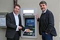 Am Hintereingang des Hausener Rathauses kann nun an einem neuen Automaten wieder Bargeld geholt werden, freuen sich Bankvorstand Thomas Endres (links) und Bürgermeister Bernd Schraud.