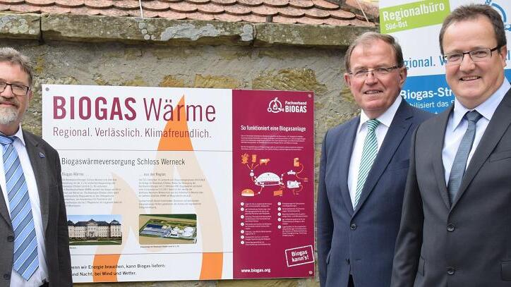 Ein Schild, überreicht vom Fachverband Biogas und seinem Regionalreferenten Markus Bäuml (links), weist am Eingang zu den Bezirkseinrichtungen Schloss Werneck auf die regenerative Energieverwendung hin. Ausgezeichnet wurde damit das Kooperationsprojekt von Bezirk, vertreten durch Bezirkstagspräsident Erwin Dotzel (Mitte), und der Bioenergie Ettleben, vertreten durch Geschäftsführer Ulrich Beck (rechts).