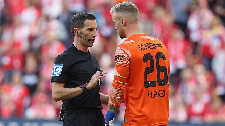 Benjamin Brand (links, hier im Zwiegespräch mit Mark Flekken, Torhüter beim SC Freiburg) ist&nbsp; nach einer längeren Verletzungspause als Bundesliga-Schiedsrichter wieder zurück auf der Fußballbühne.