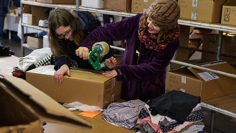 Junge Studenten sortierten am Tag der offenen Tür gespendete Kleidung, die jetzt in einer Lagerhalle für längere Zeit aufbewahrt werden kann. Junge Studenten sortierten am Tag der offenen Tür gespendete Kleidung, die jetzt in einer Lagerhalle für längere Zeit aufbewahrt werden kann.