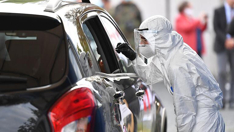 Medizinisches Fachpersonal führt an der Corona-Teststrecke auf der Talavera in Würzburg Tests durch.