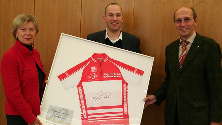 Die Auszeichnung für Schweinfurt als bester Etappenort mit einem handsignierten Trikot von Erik Zabel (von links): Oberbürgermeisterin Gudrun Grieser, Tour-Manager Mike Wilde und städtischer Wirtschaftsförderer Hans Schnabel.