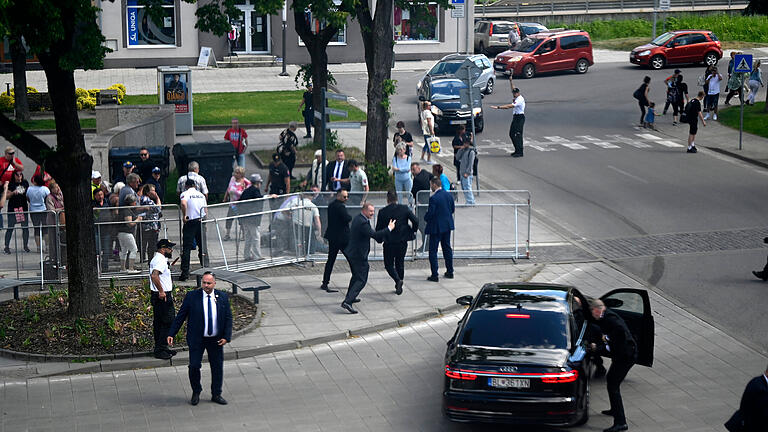 Slowakischer Regierungschef Fico angeschossen und verletzt.jpeg       -  Leibwächter bringen den slowakischen Ministerpräsidenten Robert Fico in einem Auto in Sicherheit. Fico war nach einer Kabinettssitzung in der Stadt Handlova angeschossen und verletzt worden.