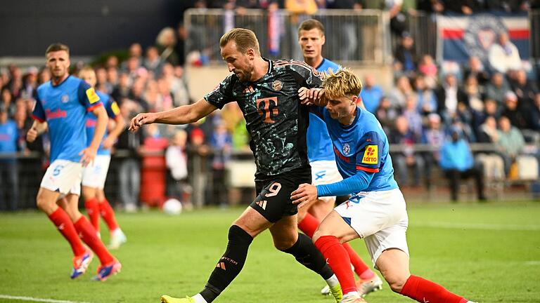 Holstein Kiel - Bayern München       -  Bayerns Harry Kane (l-r) behauptet den Ball gegen Kiels Finn Porath.