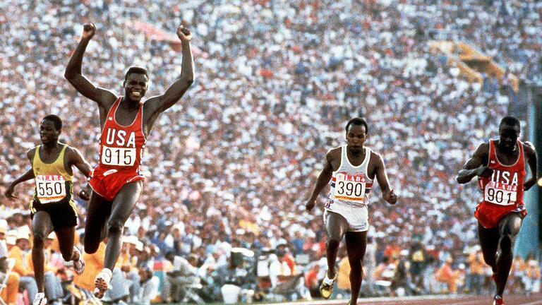 Charisma       -  Carl Lewis (M) reißt die Arme hoch, nachdem er in Los Angeles 1984 mit 9,99 Sekunden über 100 Meter gewinnt.