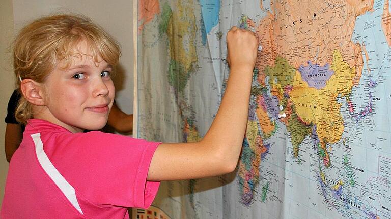 (huGO-ID: 29117578) Woher stammen die Gäste des Willkommensfestes? Lisas Mutter stammt aus Finnland, wie sie auf der Karte zeigt. FOTO Vossenkaul