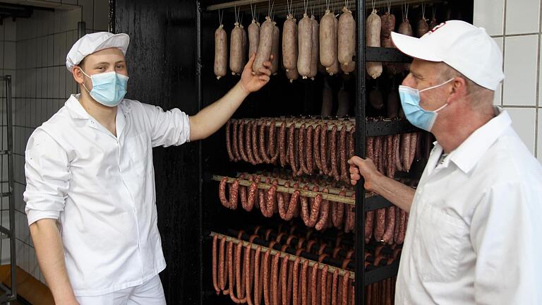 Metzgermeister aus dem Hochsauerland und aus Franken bei der gemeinsamen Arbeit in der Metzgerei der Abtei Münsterschwarzach: (von links) David Käuffer und Alfred Kolerus.