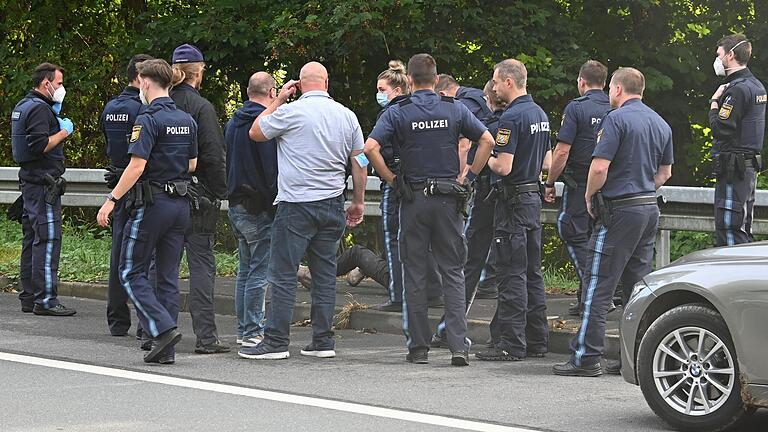 Polizeibeamte umringen den mutmaßlichen Einbrecher, nachdem er am Montag gegen 9.30 Uhr nahe der Staatsstraße zwischen Ochsenfurt und Tückelhausen festgenommen wurde. Polizeibeamte umringen den mutmaßlichen Einbrecher, nachdem er am Montag gegen 9.30 Uhr nahe der Staatsstraße zwischen Ochsenfurt und Tückelhausen festgenommen wurde.