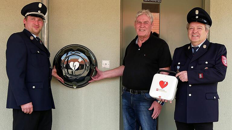 Ein neuer Defibrillator wird am Gemeindehaus in Dipbach stationiert. Bürgermeister Konrad Schlier (Mitte) dankte der Feuerwehr mit Kommandant Fabian Füller (links) und Vorsitzendem Werner Fuchs für die Spende.