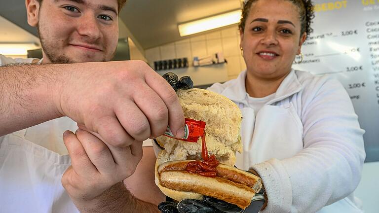 Ist das noch eine fränkische Wurst? Nach der Übernahme des Knüpfing-Stands am unteren Markt bietet Jan Wiesner die Bratwurst nun auch mit Ketchup an. Mitarbeiterin Silmara Pacheco-Helle und Mitarbeiter Luka Pejic demonstrieren dies.&nbsp;