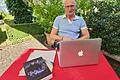 Hubert Ziegler Autor Bulle und Finn Nüdlingen       -  Hubert Ziegler alias Orlando Stein in seinem Garten, wo er am Laptop schreibt. Vor ihm sein Debüt-Roman: 'Bulle und Finn'.