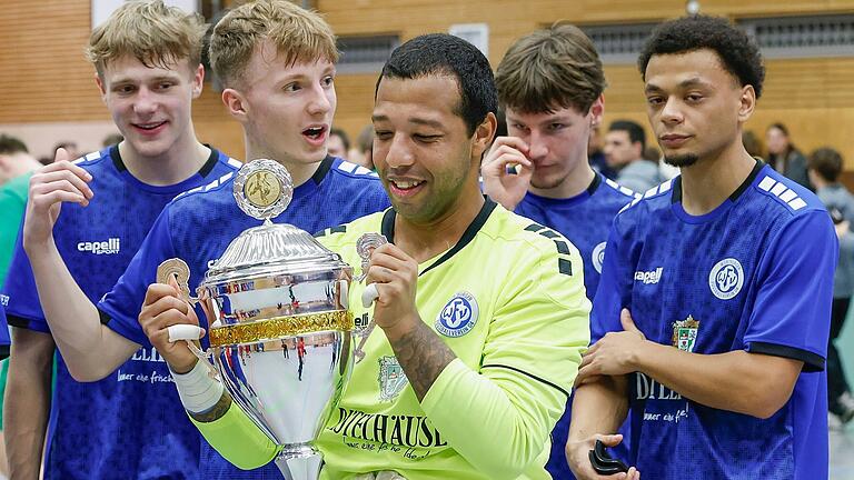 Torhüter René Rudi (vorne) vom Würzburger FV betrachtet den Pokal für den Sieg beim Bergtheimer Hallenturnier um den EEV-Cup. Im Hintergrund (von links): die Mitspieler David Esau, Joscha Obrusnik, Heorhii Nachkebiia und Michael Pruitt Torhüter René Rudi (vorne) vom Würzburger FV betrachtet den Pokal für den Sieg beim Bergtheimer Hallenturnier um den EEV-Cup. Im Hintergrund (von links): die Mitspieler David Esau, Joscha Obrusnik, Heorhii Nachkebiia und Michael Pruitt