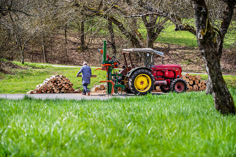 Noch für das Frühjahr oder schon für den nächsten Winter? In Mechenried füllt ein Mann mit Traktor und Holzspalter die Holzvorräte wieder auf.