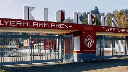 Das Kickers-Stadion am Dallenberg erhält einen neuen Namen - (frak) Die rote Farbe ist gerade erst getrocknet. Die Kassenhäuschen haben einen neuen Anstrich bekommen. Über dem Eingang steht schon der neue Name. Am Würzburger Dallenberg hat sich – quasi über Nacht – einiges getan. Das Entscheidende: Das Kickers-Stadion heißt ab sofort „flyeralarm Arena“. Die Online-Druckerei flyeralarm und ihr Geschäftsführer Thorsten Fischer sind – das ist kein Geheimnis – seit Jahren die wichtigsten Unterstützer des Fußball-Regionalligisten. Nun hat sich das Würzburger Unternehmen, das laut eigener Pressemitteilung im Vorjahr einen Umsatz von 260 Millionen Euro erwirtschaftet hat, für die kommenden drei Jahre die Namensrechte an der vereinseigenen Spielstätte gesichert. Welche Summe dafür in die Kickers-Vereinskasse fließt, darüber hüllen sich die Beteiligten in Schweigen. Nur so viel: „Es ist für beide Seiten ein lukratives Geschäft“, sagt Kickers-Vorstandsvorsitzender Michael Schlagbauer auf Nachfrage dieser Zeitung. flyeralarm-Geschäftsführer Thorsten Fischer findet indes viele lobende Worte für den Klub: „Die Würzburger Kickers sind ein Traditionsverein, authentisch und aus der Stadt nicht wegzudenken. Sie gehen mit voller Kraft voran. Das Kickers-Stadion kennt fast jeder. Dass sich der Verein zur Umbenennung entschlossen hat und wir Namensgeber sein durfte, macht uns stolz“, wird er in einer Pressemitteilung der Firma zitiert. In den kommenden Monaten wollen die Rothosen ihr Gelände indes weiter modernisieren. „Wir erstellen derzeit eine Prioritätenliste“, sagt Schlagbauer. Es ist ein offenes Geheimnis, dass darauf auch eine Flutlichtanlage auftaucht. Die Planungen laufen. Wann mit dem Bau begonnen werde, sei aber noch offen, so Schlagbauer: „Es gibt im Hinblick auf mögliche Großveranstaltungen zunächst noch andere Dinge, die erledigt werden sollten.“ So wird derzeit ein Teil der Stehränge neu befestigt. „Wir modernisieren unser Stadion nicht nur für uns. Es ist auch unser gemeinsames Ziel, für die gesamte Region ein vernünftiges Stadion bereitzustellen“, sagt Schlagbauer. Die Kickers tragen seit 46 Jahren ihre Heimspiele im 14 500 Zuschauer fassenden Stadion am Dallenberg aus. „Wir wollen nicht mit alten Traditionen brechen, sondern die Möglichkeit nutzen, den Verein weiterzuentwickeln“, betont Schlagbauer. Das erste Regionalliga-Heimspiel in der „flyeralarm Arena“ findet am Samstag (14 Uhr) gegen Hof statt. Das Kickers-Stadion am Dallenberg erhält einen neuen Namen - (frak) Die rote Farbe ist gerade erst getrocknet. Die Kassenhäuschen haben einen neuen Anstrich bekommen. Über dem Eingang steht schon der neue Name. Am Würzburger Dallenberg hat sich – quasi über Nacht – einiges getan. Das Entscheidende: Das Kickers-Stadion heißt ab sofort „flyeralarm Arena“. Die Online-Druckerei flyeralarm und ihr Geschäftsführer Thorsten Fischer sind – das ist kein Geheimnis – seit Jahren die wichtigsten Unterstützer des Fußball-Regionalligisten. Nun hat sich das Würzburger Unternehmen, das laut eigener Pressemitteilung im Vorjahr einen Umsatz von 260 Millionen Euro erwirtschaftet hat, für die kommenden drei Jahre die Namensrechte an der vereinseigenen Spielstätte gesichert. Welche Summe dafür in die Kickers-Vereinskasse fließt, darüber hüllen sich die Beteiligten in Schweigen. Nur so viel: „Es ist für beide Seiten ein lukratives Geschäft“, sagt Kickers-Vorstandsvorsitzender Michael Schlagbauer auf Nachfrage dieser Zeitung. flyeralarm-Geschäftsführer Thorsten Fischer findet indes viele lobende Worte für den Klub: „Die Würzburger Kickers sind ein Traditionsverein, authentisch und aus der Stadt nicht wegzudenken. Sie gehen mit voller Kraft voran. Das Kickers-Stadion kennt fast jeder. Dass sich der Verein zur Umbenennung entschlossen hat und wir Namensgeber sein durfte, macht uns stolz“, wird er in einer Pressemitteilung der Firma zitiert. In den kommenden Monaten wollen die Rothosen ihr Gelände indes weiter modernisieren. „Wir erstellen derzeit eine Prioritätenliste“, sagt Schlagbauer. Es ist ein offenes Geheimnis, dass darauf auch eine Flutlichtanlage auftaucht. Die Planungen laufen. Wann mit dem Bau begonnen werde, sei aber noch offen, so Schlagbauer: „Es gibt im Hinblick auf mögliche Großveranstaltungen zunächst noch andere Dinge, die erledigt werden sollten.“ So wird derzeit ein Teil der Stehränge neu befestigt. „Wir modernisieren unser Stadion nicht nur für uns. Es ist auch unser gemeinsames Ziel, für die gesamte Region ein vernünftiges Stadion bereitzustellen“, sagt Schlagbauer. Die Kickers tragen seit 46 Jahren ihre Heimspiele im 14 500 Zuschauer fassenden Stadion am Dallenberg aus. „Wir wollen nicht mit alten Traditionen brechen, sondern die Möglichkeit nutzen, den Verein weiterzuentwickeln“, betont Schlagbauer. Das erste Regionalliga-Heimspiel in der „flyeralarm Arena“ findet am Samstag (14 Uhr) gegen Hof statt.