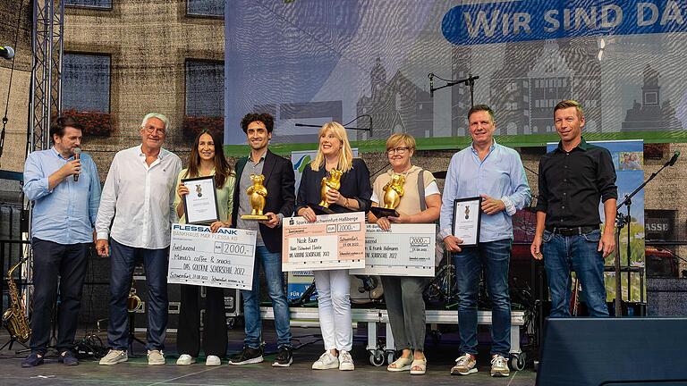 Bei der 'Schörschle'-Verleihung auf der Stadtfestbühne am Marktplatz (von links): Moderator Sven Schröter, Werner Christoffel (Schweinfurt erleben), Diana und Manoli Skafidas (Manolis coffee &amp; snacks), Nicole Bauer (Nicole Bauer - Haare, Schönheit, Seele), Marion und Frank Hoffmann und Thomas Hermann (Citymanager)