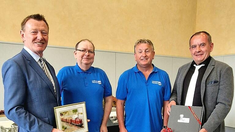 Gastgeschenke überreichten die Gaubahnfreunde beim Empfang zu ihrer Schau. Im Bild (von links): Bürgermeister Peter Juks, die Gaubahnfreunde Klaus Stäck und Uwe Sieber, stellvertretender Landrat Alois Fischer.