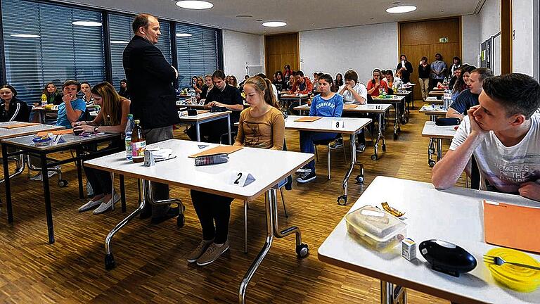 Deutsch zum Auftakt &ndash; Die Abiturprüfungen haben begonnen       -  (ir)   Für die Gymnasiasten im Landkreis haben am Freitag die Abiturprüfungen begonnen. 139 Schüler des Rhön-Gymnasiums Bad Neustadt, 61 Schüler am Martin-Pollich-Gymnasium in Mellrichstadt und 86 Gymnasiasten in Bad Königshofen starteten mit Prüfungen im Fach Deutsch. Am kommenden Freitag werden dann alle Kandidaten über den Mathematik-Aufgaben brüten. Kurze Verschnaufpause am Wochenende, denn am Dienstag wird das dritte Abiturfach geprüft, das innerhalb gewisser Vorgaben frei wählbar ist. In den zwei Wochen nach Pfingsten steht in Bad Neustadt wie auch in Mellrichstadt noch das Kolloquium, also die mündlichen Prüfungen im vierten und fünften Abiturfach an. Für die, die nicht noch in die Nachprüfung müssen oder wollen, ist die Reifeprüfung dann geschafft. Auf dem Bild erklärt der Lehrer Ivo Hawlitschek den Bad Neustädter Gymnasiasten die Verhaltensregeln während der Prüfung.