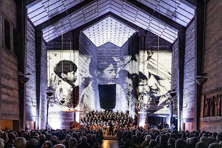 Beim Gedenkkonzert anlässlich der Zerstörung Würzburgs unterstrich eine Lichtinstallation mit Porträts von 'Peacemakers' die bewegende Musik in der Johanniskirche in Würzburg. Beim Gedenkkonzert anlässlich der Zerstörung Würzburgs unterstrich eine Lichtinstallation mit Porträts von 'Peacemakers' die bewegende Musik in der Johanniskirche in Würzburg.