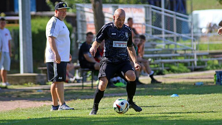 Daniel Hey, Spielertrainer der SpVgg Hambach, am Ball. Hinter ihm steht links Poppenhausens Trainer Alexander Hümpfer.