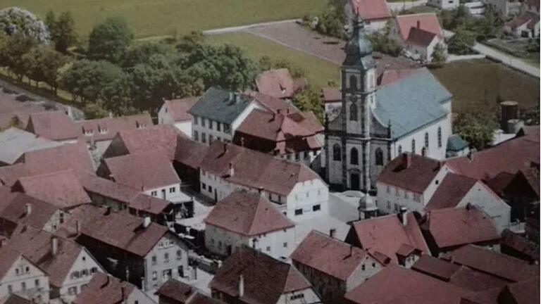 Über lange Jahre bewahrte die FFW Unterspiesheim im Gebäude der Alten Schule (unmittelbar links neben der Kirche) ihre Gerätschaften auf. In der Gerätehalle hinter der Kirche waren Mitte des 18. Jahrhunderts zwei Druckspritzen mit Schlauchmaterial untergebracht. Weitere Geräte waren im Haus des Flurers aufbewahrt. Das Luftbild stammt aus der Zeit um 1900.