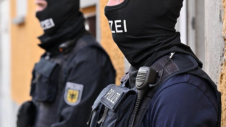 Razzia       -  Bundespolizisten stehen vor einem Hauseingang. (Archivbild)