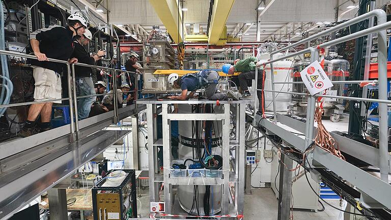 Das Cern-Team arbeitet an dem von Bilfinger Noell in Würzburg gebauten supraleitenden Magneten (Bildmitte). Der Apparat soll bei der Grundlagenforscher der Physiker helfen.