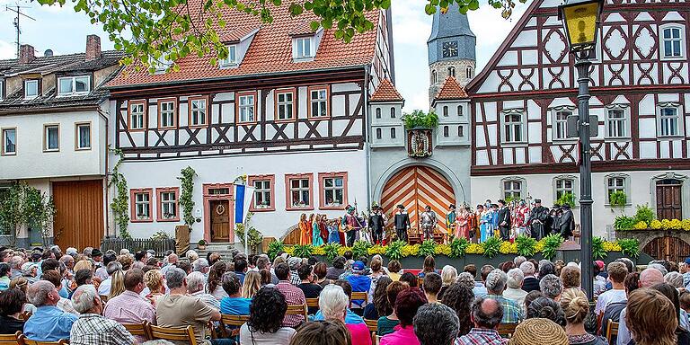 Szene aus dem Heimatspiel „Die Jungfrau von Münnerstadt“ auf dem Anger vor der historischen Kulisse des Heimatspielhaus-Ensembles mit der Stadtpfarrkirche im Hintergrund.
