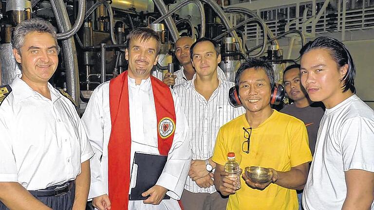 Arbeitsplatz Singapur: Seemannspfarrer Christian Schmidt mit asiatischen Matrosen und dem Schiffskapitän. Arbeitsplatz Singapur: Seemannspfarrer Christian Schmidt mit asiatischen Matrosen und dem Schiffskapitän.