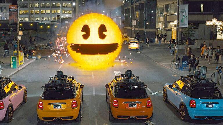 Kinostart 'Pixels'       -  Schräge Weltuntergangs-Komödie: Szene aus &bdquo;Pixels&ldquo;, in der sich ein überdimensionierter Pac-Man durch die Straßen mampft.