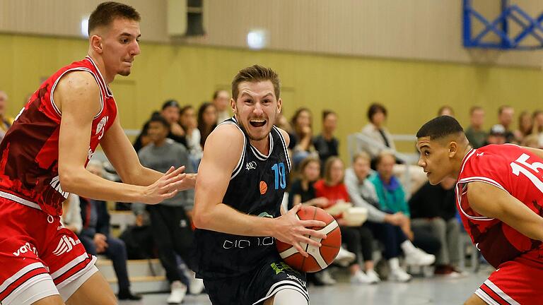 Luka Galic (links) und Tyrese Leonce von der Würzburg Baskets Akademie verteidigen gegen Maximilian Heckel von der TG Sprintis Veitshoechheim. Im Lokalderby in der Nord-Gruppe der 1. Regionalliga Südost gewannen die Veitshöchheimer ihr drittes Saisonspiel, während die Baskets zum dritten Mal verloren.