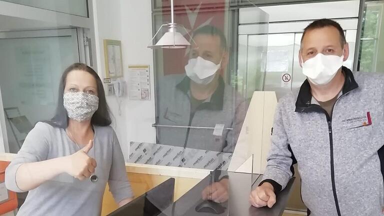 Geschützter Empfang: Jacqueline Schenk von der Klinik von Weckbecker und Schreiner Heiko Hergenröder testen die neue Wand aus Plexiglas. Foto: Ingrid Jehn       -  Geschützter Empfang: Jacqueline Schenk von der Klinik von Weckbecker und Schreiner Heiko Hergenröder testen die neue Wand aus Plexiglas. Foto: Ingrid Jehn