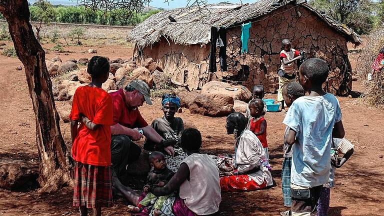 Klaus Rehrmann inmitten einer Gruppe Massai im Namelok-Gebiet in Kenia. In Hütten, wie im Bild zu sehen, hat er bei seinen Aufenthalten schon häufiger übernachtet.