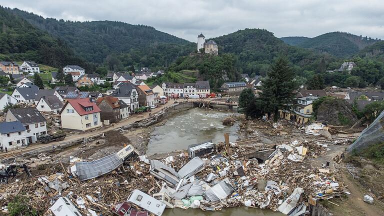 Nach der Flutkatastrophe im Ahrtal.jpeg       -  Meterhoch türmen sich Wohnwagen, Gastanks, Bäume und Schrott an einer Brücke über der Ahr in Altenahr. Das waren die Auswirkungen eines der heftigsten Hochwasser der vergangenen 100 Jahre.