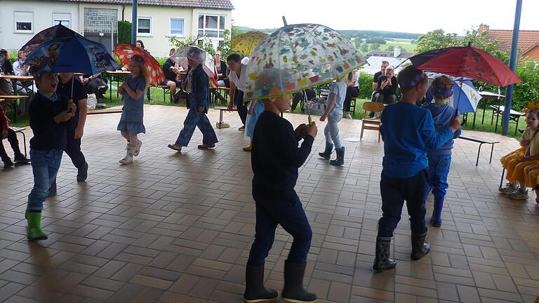 Das Foto zeigt die Kindergartenkinder beim Regentanz.