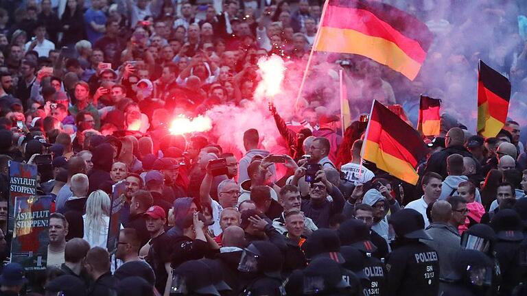 Rechte demonstrieren in Chemnitz       -  Demonstranten zünden in Chemnitz Pyrotechnik und schwenken Deutschlandfahnen. Foto: Jan Woitas