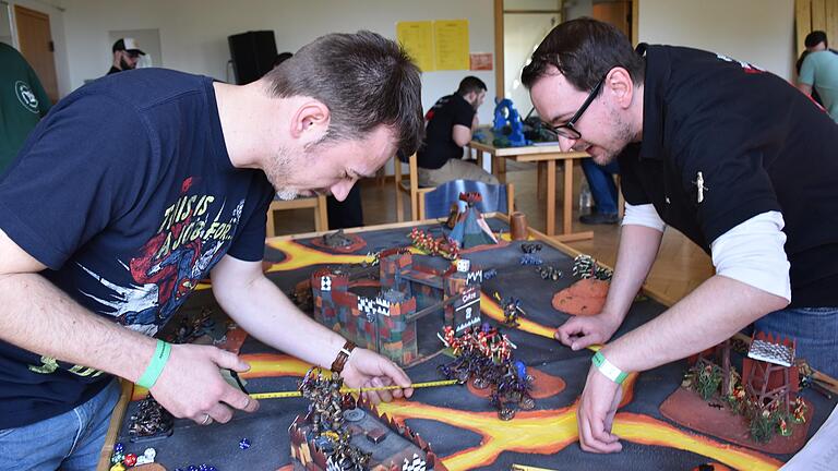 Tabletop-Spiele sind Millimeterarbeit: Nach einem Spielzug wird genau ausgemessen, welche Auswirkungen dieser auf den Verlauf der 'Schlacht' hat. Die Kontrahenten, wie hier 'Mucki' und 'Vile', geben sich dafür auch gerne Fantasienamen. Tabletop-Spiele sind Millimeterarbeit: Nach einem Spielzug wird genau ausgemessen, welche Auswirkungen dieser auf den Verlauf der 'Schlacht' hat. Die Kontrahenten, wie hier 'Mucki' und 'Vile', geben sich dafür auch gerne Fantasienamen.