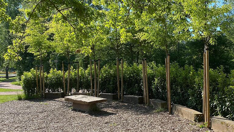 Zwei Bereiche, die mit Hecken eingefasst sind, laden am Spielplatz 'Am Maradies' zum Verweilen ein.