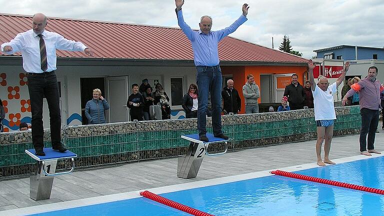 Zum Absprung bereit. Das offizielle Anschwimmen zur Wiedereröffnung des Gelchsheimer Freibads wurde mit kompletter Bekleidung vollzogen. In der Mitte Franz Mark vom Arbeitskreis der freiwilligen Helfer, die 7000 Stunden gearbeitet hatten, links Landrat Eberhard Nuß.